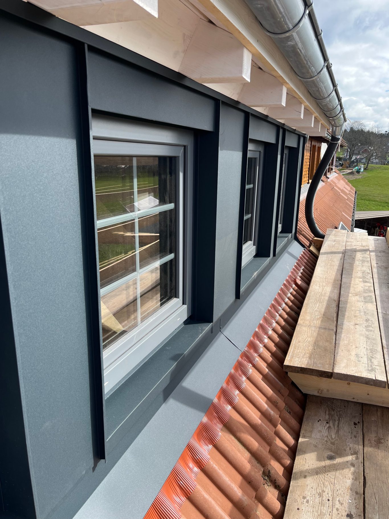 Gaubenfront, Alu anthrazit Gaubenfrontverkleidung aus anthrazitem Aluminium, Anschlüsse an Fenster und Ziegel